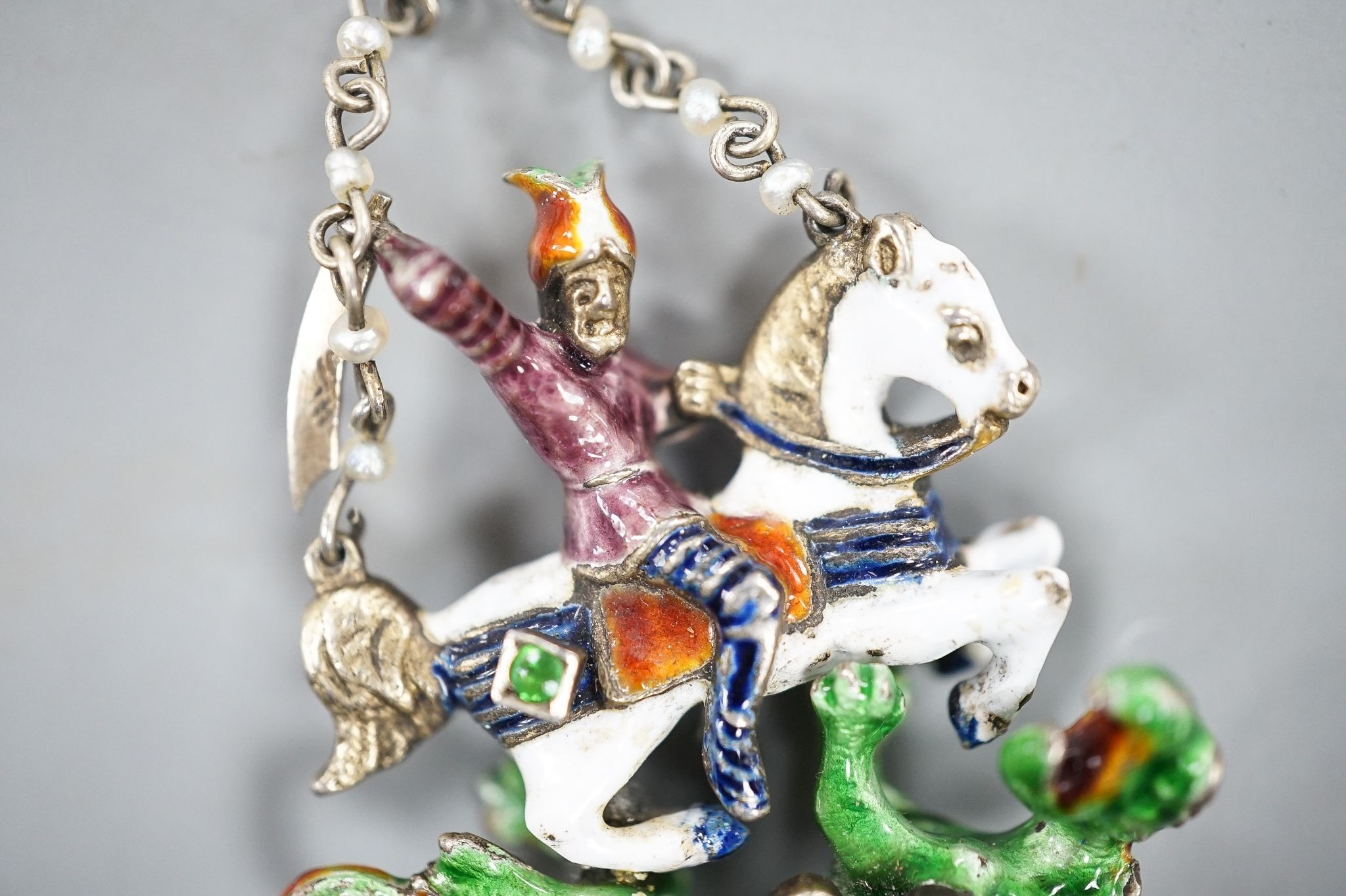 A 19th century Austro-Hungarian? gilt white metal, polychrome enamel, seed pearl and gem set 'St George & The Dragon' drop pendant, 4cm.